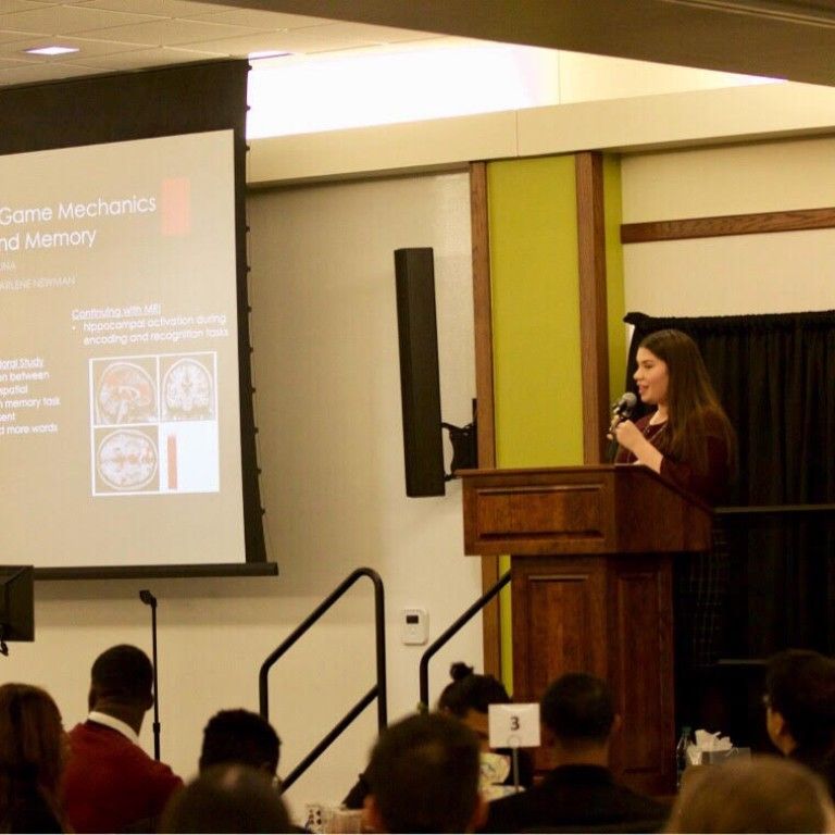 Deanna Molina giving a presentation on the impact of video game mechanics on learning and memory