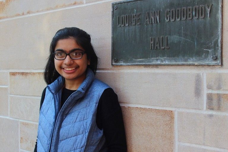 Neha standing by a sign for Louise Ann Goodbody Hall