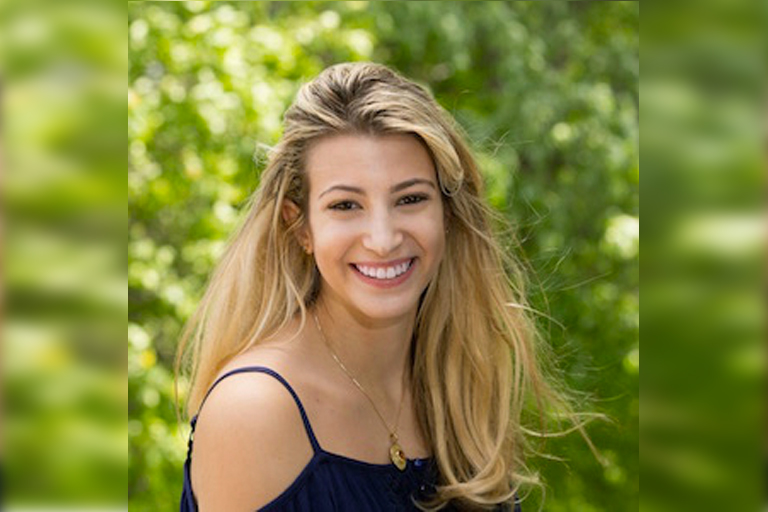A headshot of a smiling woman with long blond hair